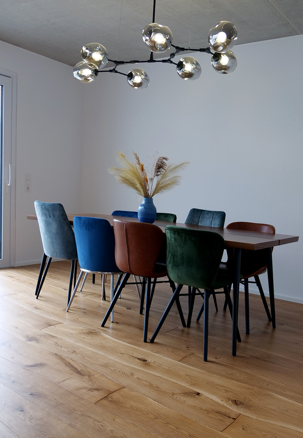 Oak Curved Flooring in living room with colored chairs and live-edge dining table