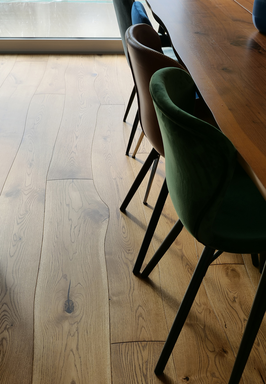 Oak Curved Flooring in living room with colored chairs and live-edge dining table